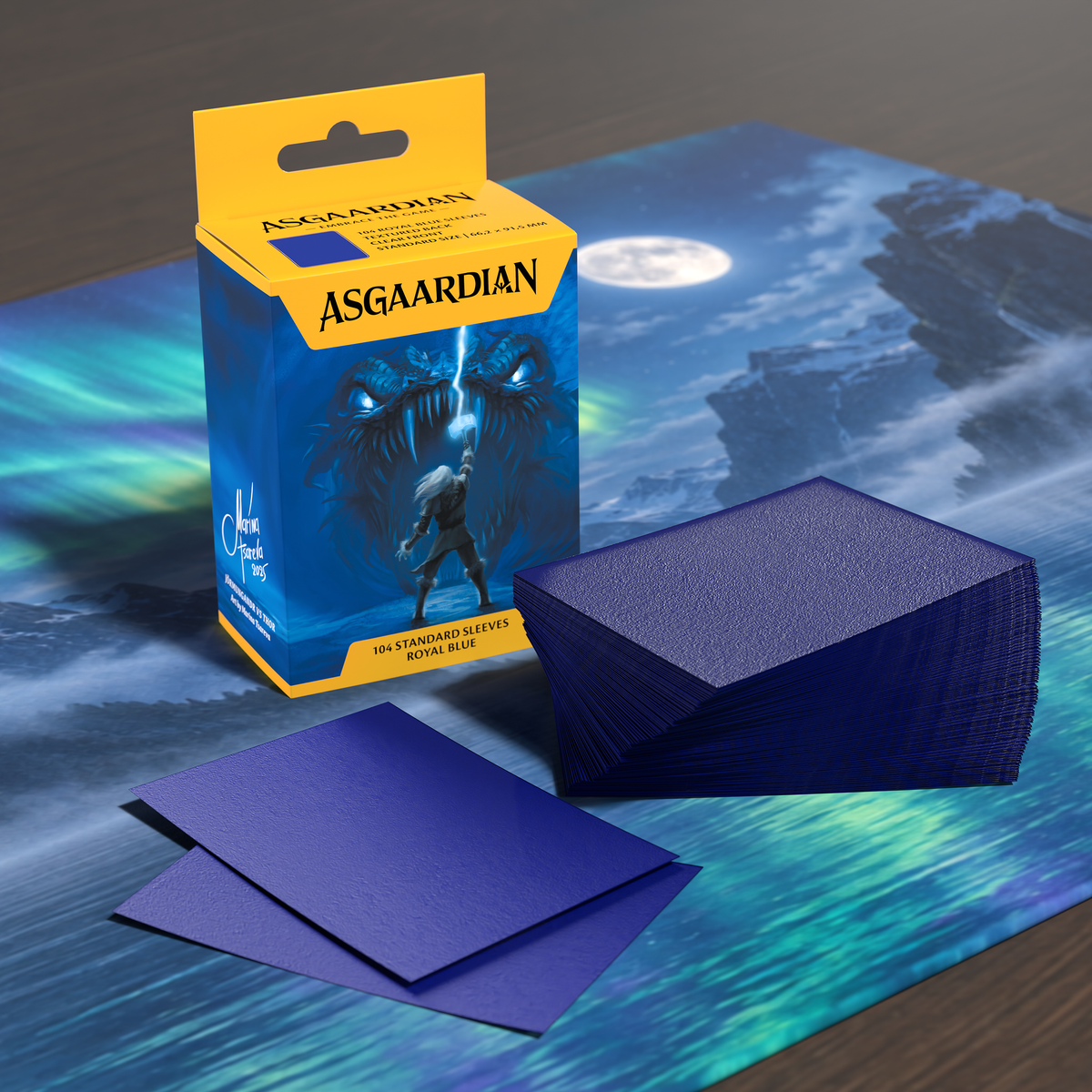 Asgaardian 1103 Royal Blue standard card sleeves on a playmat: retail box of 104, a stack of sleeves and two loose sleeves